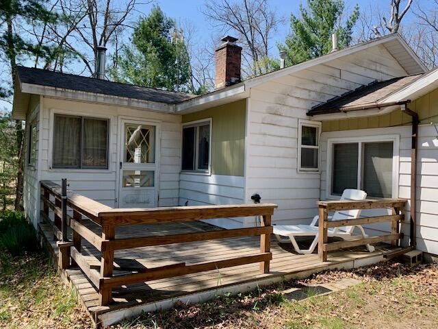 4827 W Unora Park Dr, Baldwin, MI 49304 - rear view of house with a chimney and a wooden deck