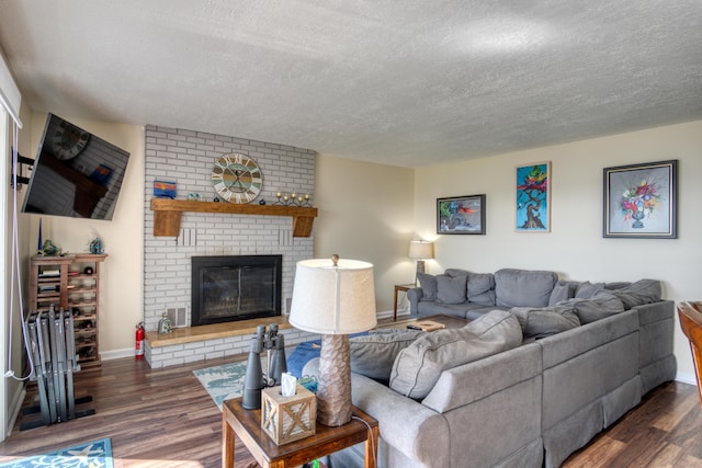 108 Eastbrook Ave, Houghton Lake, MI 48629 - living room with a textured ceiling, wood finished floors, a brick fireplace, and baseboards