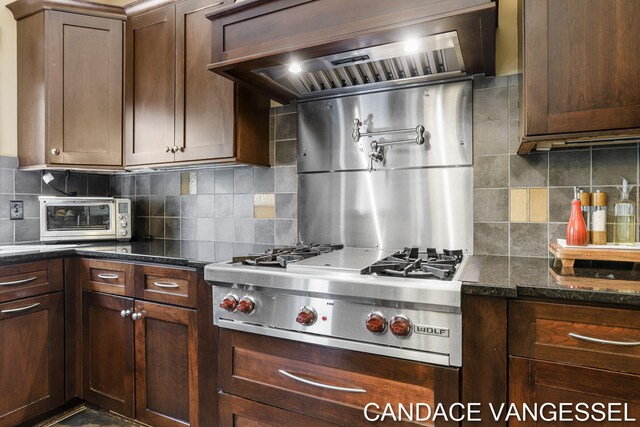 2429 Shears Crossing Ct NE, Grand Rapids, MI 49525 - kitchen with stainless steel gas stovetop, premium range hood, decorative backsplash, and dark stone countertops