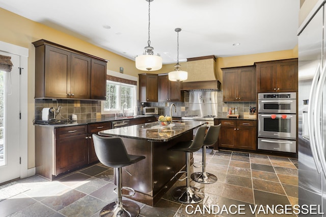 2429 Shears Crossing Ct NE, Grand Rapids, MI 49525 - kitchen featuring a warming drawer, stone tile flooring, premium range hood, tasteful backsplash, and recessed lighting