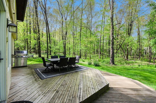 8461 Webster Hills Rd, Dexter, MI 48130 - deck with outdoor dining area, grilling area, a yard, and a view of trees