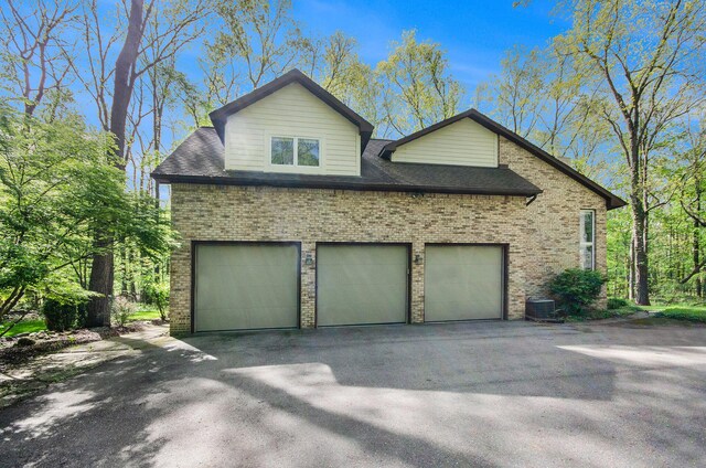 8461 Webster Hills Rd, Dexter, MI 48130 - view of side of property featuring brick siding, asphalt driveway, and central air condition unit