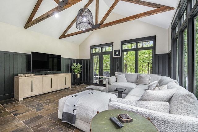 4850 Catamount Trl NE, Ada, MI 49301 - living area featuring stone tile floors, high vaulted ceiling, beamed ceiling, a wainscoted wall, and french doors