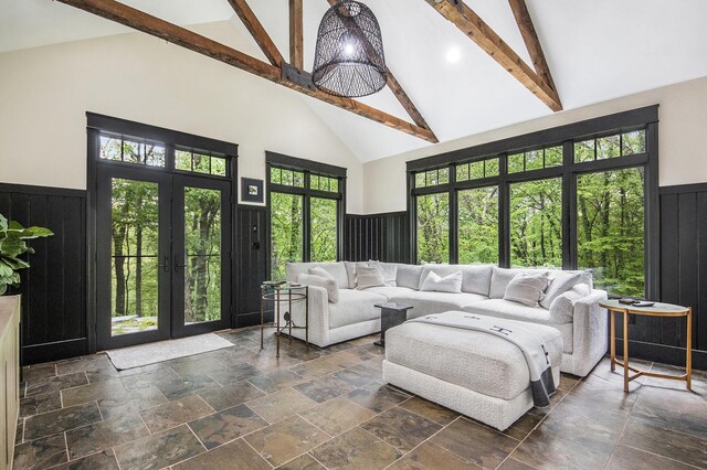 4850 Catamount Trl NE, Ada, MI 49301 - living room featuring high vaulted ceiling, french doors, stone tile flooring, beamed ceiling, and a wainscoted wall