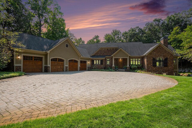 4850 Catamount Trl NE, Ada, MI 49301 - craftsman-style house with stone siding, decorative driveway, an attached garage, a chimney, and a lawn