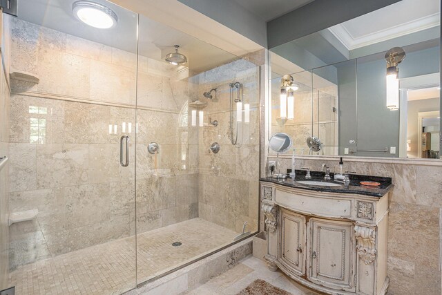 4850 Catamount Trl NE, Ada, MI 49301 - bathroom featuring a shower stall, vanity, tile walls, and ornamental molding