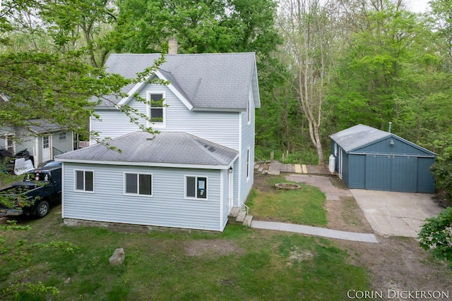 151 Park Ave, Allegan, MI 49010 - back of house featuring a lawn, an outbuilding, a shingled roof, and a chimney