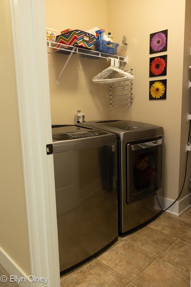 16894 Arbor Way Dr, Nunica, MI 49448 - clothes washing area with washer and dryer, light tile patterned floors, and baseboards