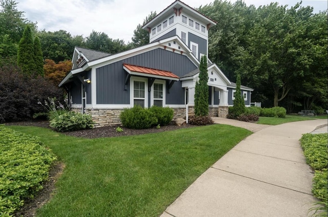 16894 Arbor Way Dr, Nunica, MI 49448 - view of front of property with stone siding, a front yard, and board and batten siding