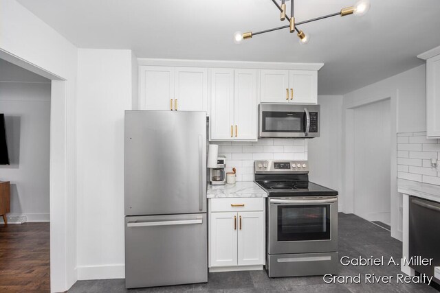 kitchen featuring stainless steel appliances, tasteful backsplash, white cabinets, baseboards, and light stone countertops