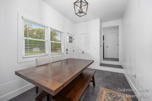 dining space featuring a chandelier and baseboards