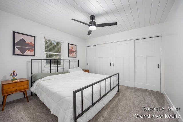 bedroom with light carpet, a closet, a ceiling fan, and wooden ceiling