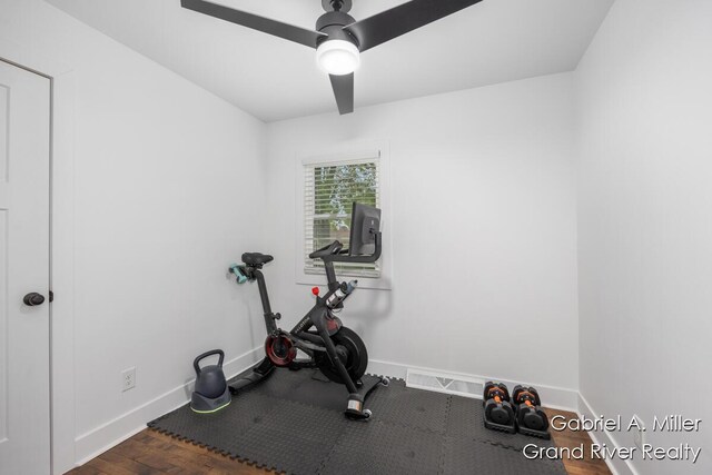 exercise area featuring baseboards, wood finished floors, and ceiling fan