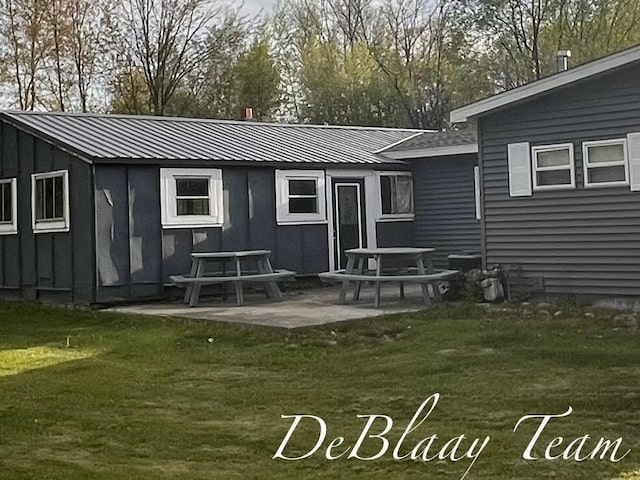 6061 Cutler Rd, Lakeview, MI 48850 - rear view of property featuring board and batten siding, a yard, metal roof, and a patio