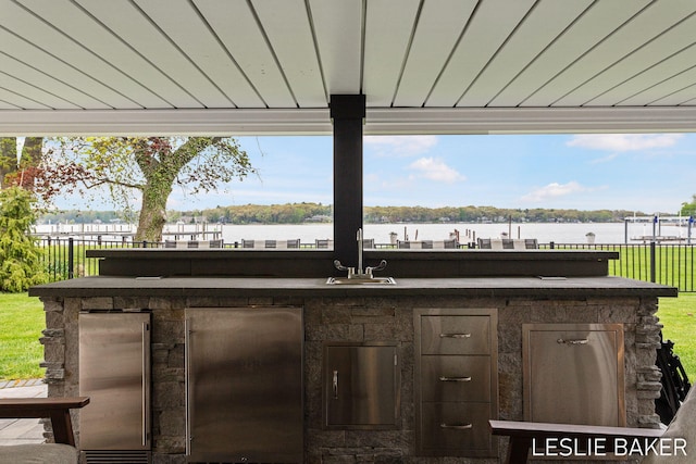 833 Allen Dr, Holland, MI 49423 - view of patio featuring area for grilling, a sink, fence, and a water view