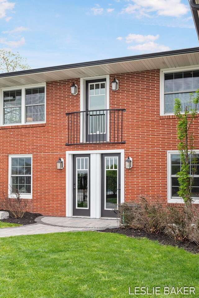 833 Allen Dr, Holland, MI 49423 - view of front of home featuring a balcony, a front lawn, brick siding, and a patio