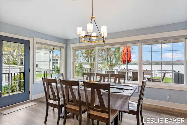 833 Allen Dr, Holland, MI 49423 - dining space featuring healthy amount of natural light, a water view, a chandelier, and baseboards