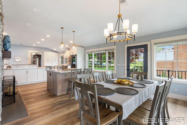 833 Allen Dr, Holland, MI 49423 - dining room with light wood-type flooring, a chandelier, vaulted ceiling, recessed lighting, and baseboards