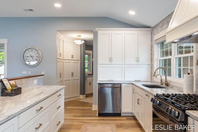 833 Allen Dr, Holland, MI 49423 - kitchen featuring dishwasher, a sink, custom range hood, vaulted ceiling, and gas stove
