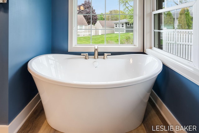 833 Allen Dr, Holland, MI 49423 - full bathroom with baseboards, wood finished floors, and a soaking tub