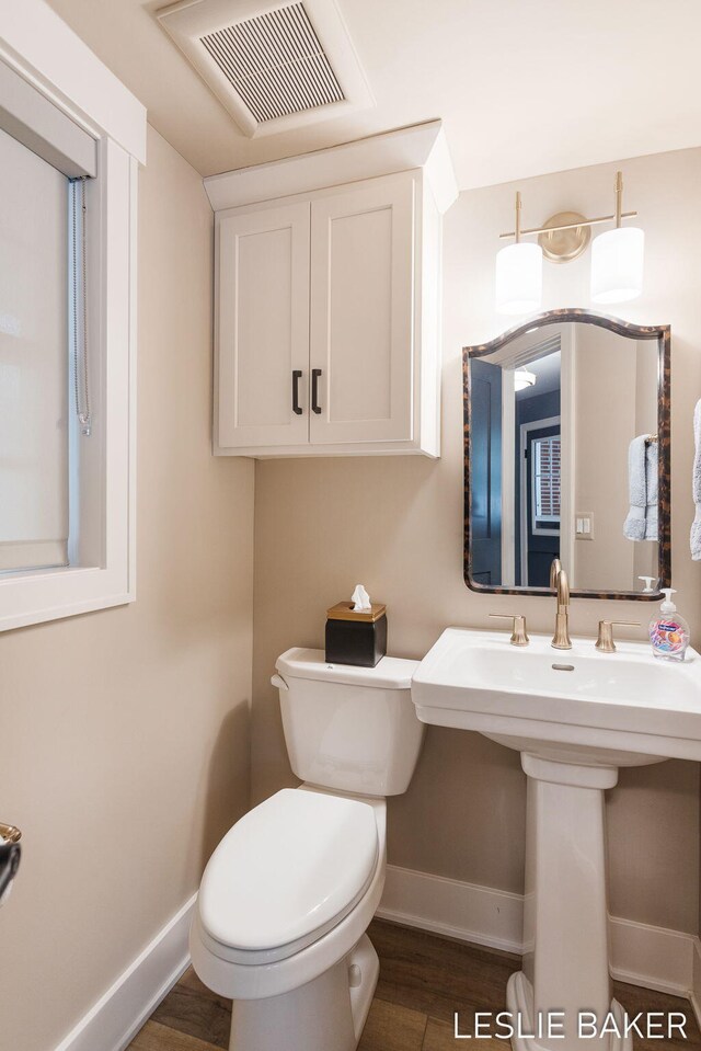 833 Allen Dr, Holland, MI 49423 - half bathroom with baseboards, wood finished floors, and toilet