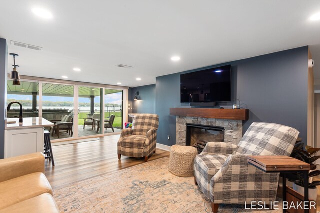 833 Allen Dr, Holland, MI 49423 - living area featuring wood finished floors, expansive windows, recessed lighting, a fireplace, and baseboards