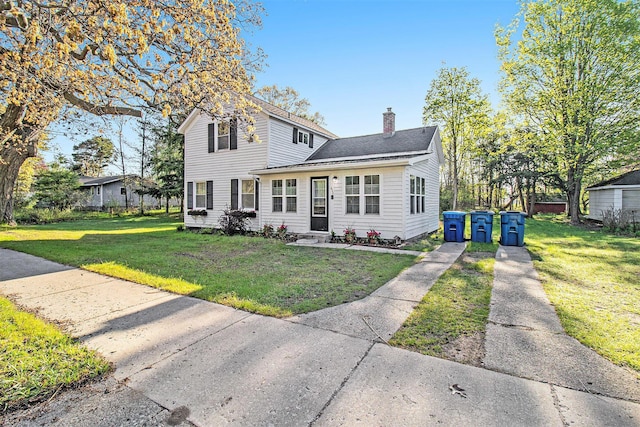 620 N Lakeshore Dr, Ludington, MI 49431 - traditional-style home with a chimney and a front yard