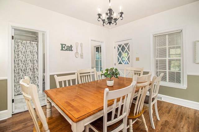 620 N Lakeshore Dr, Ludington, MI 49431 - dining room featuring baseboards, wood finished floors, and a chandelier
