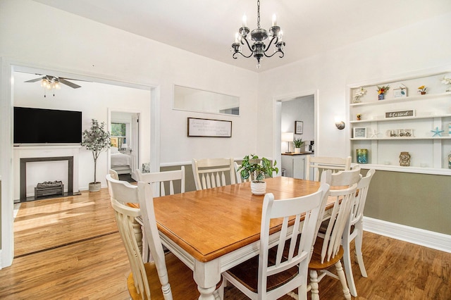 620 N Lakeshore Dr, Ludington, MI 49431 - dining area with light wood finished floors, a chandelier, a ceiling fan, and baseboards