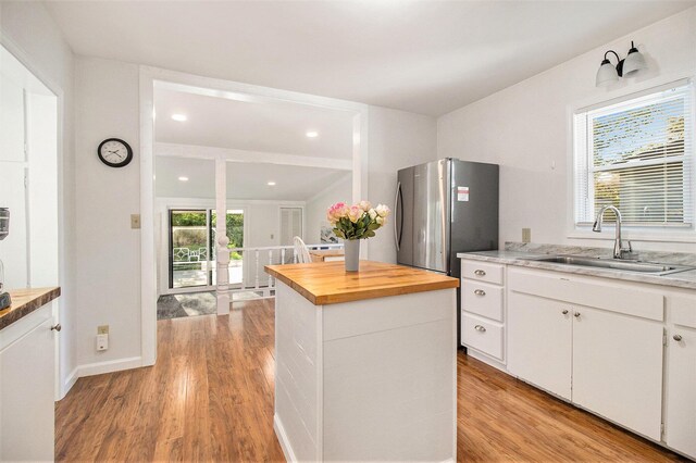 620 N Lakeshore Dr, Ludington, MI 49431 - kitchen featuring a sink, butcher block countertops, light wood-type flooring, a kitchen island, and freestanding refrigerator