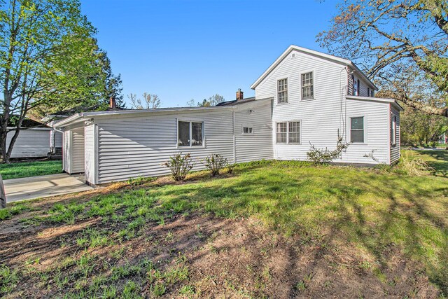 620 N Lakeshore Dr, Ludington, MI 49431 - rear view of house with a lawn and a chimney