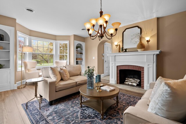 46132 86th Ave, Decatur, MI 49045 - living area with wood finished floors, arched walkways, a chandelier, a brick fireplace, and baseboards