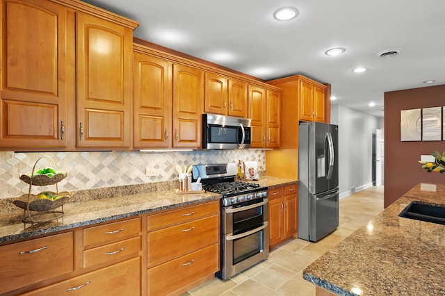 46132 86th Ave, Decatur, MI 49045 - kitchen featuring appliances with stainless steel finishes, stone countertops, tasteful backsplash, brown cabinetry, and recessed lighting