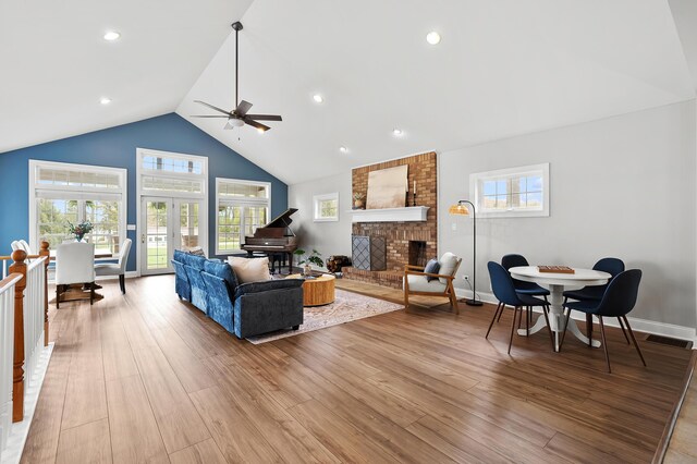 46132 86th Ave, Decatur, MI 49045 - living area with ceiling fan, a brick fireplace, light wood-style floors, high vaulted ceiling, and baseboards