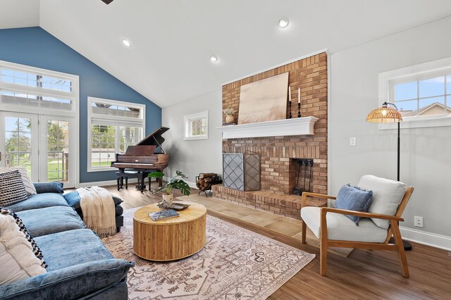 46132 86th Ave, Decatur, MI 49045 - living room with healthy amount of natural light, a brick fireplace, wood finished floors, high vaulted ceiling, and baseboards