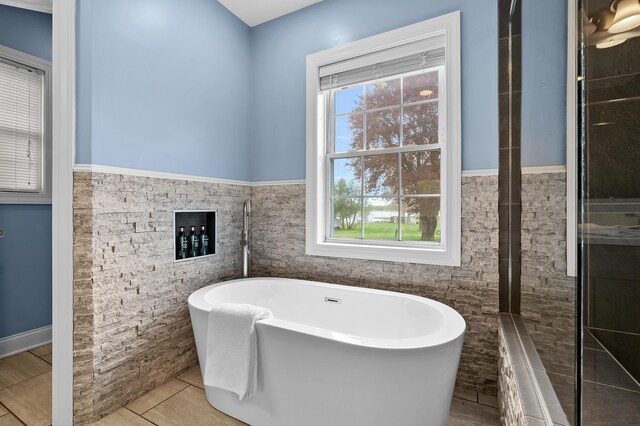46132 86th Ave, Decatur, MI 49045 - full bath with tile walls, a freestanding bath, a wainscoted wall, and tile patterned flooring