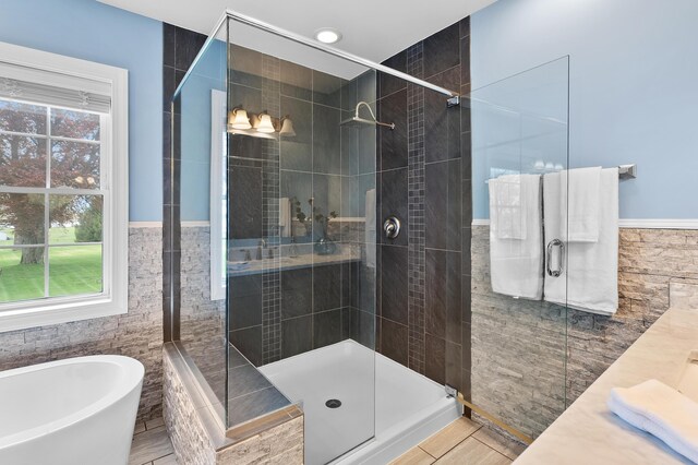 46132 86th Ave, Decatur, MI 49045 - bathroom featuring tile walls, a soaking tub, a stall shower, vanity, and a wainscoted wall