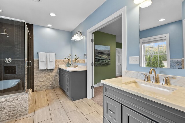 46132 86th Ave, Decatur, MI 49045 - bathroom featuring a stall shower, recessed lighting, two vanities, tile walls, and wainscoting