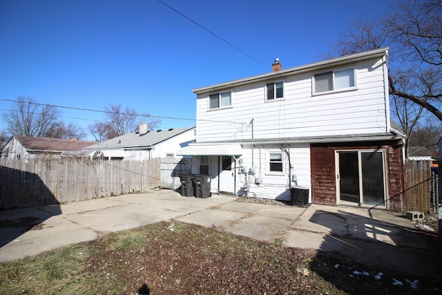 rear view of property with a patio area, fence, and a chimney