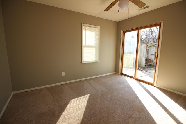 empty room with light carpet, a ceiling fan, and plenty of natural light