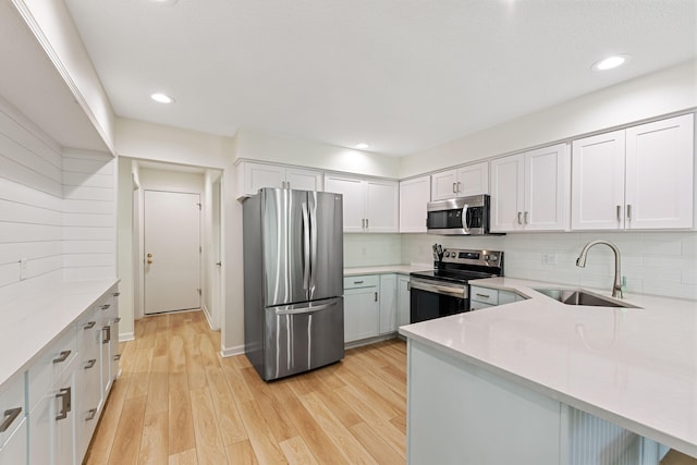 9773 Weko Dr, Bridgman, MI 49106 - kitchen featuring appliances with stainless steel finishes, a sink, light countertops, light wood finished floors, and recessed lighting