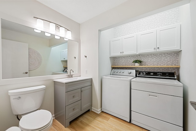 9773 Weko Dr, Bridgman, MI 49106 - bathroom with washing machine and clothes dryer, wood finished floors, toilet, and vanity