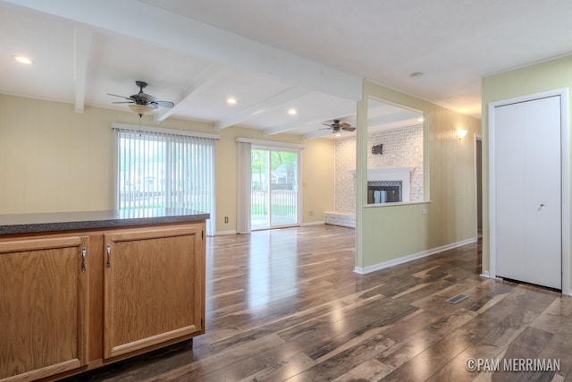 8220 Indian Shores Dr, Howard City, MI 49329 - unfurnished living room with a ceiling fan, dark wood-style flooring, beamed ceiling, a fireplace, and baseboards