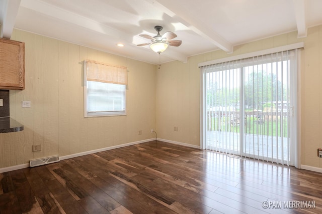 8220 Indian Shores Dr, Howard City, MI 49329 - empty room with dark wood-type flooring, beamed ceiling, plenty of natural light, ceiling fan, and baseboards
