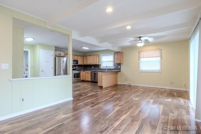 8220 Indian Shores Dr, Howard City, MI 49329 - kitchen featuring stainless steel appliances, open floor plan, wood finished floors, beam ceiling, and dark countertops