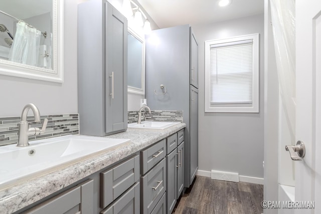8220 Indian Shores Dr, Howard City, MI 49329 - bathroom with tasteful backsplash, wood finished floors, double vanity, and curtained shower
