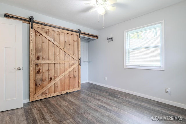 8220 Indian Shores Dr, Howard City, MI 49329 - unfurnished bedroom featuring a barn door, wood finished floors, and baseboards