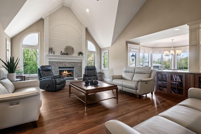 4624 Parman Rd, Stockbridge, MI 49285 - living room with a chandelier, a large fireplace, healthy amount of natural light, dark wood-style floors, and high vaulted ceiling