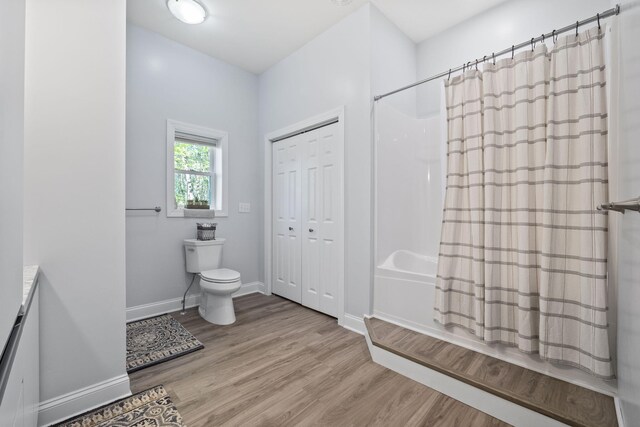 4624 Parman Rd, Stockbridge, MI 49285 - full bathroom featuring wood finished floors, toilet, shower / bathtub combination with curtain, baseboards, and vanity