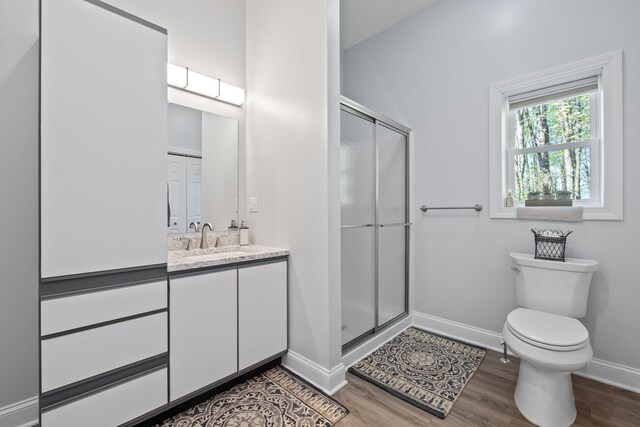4624 Parman Rd, Stockbridge, MI 49285 - full bath with wood finished floors, a shower stall, baseboards, toilet, and vanity